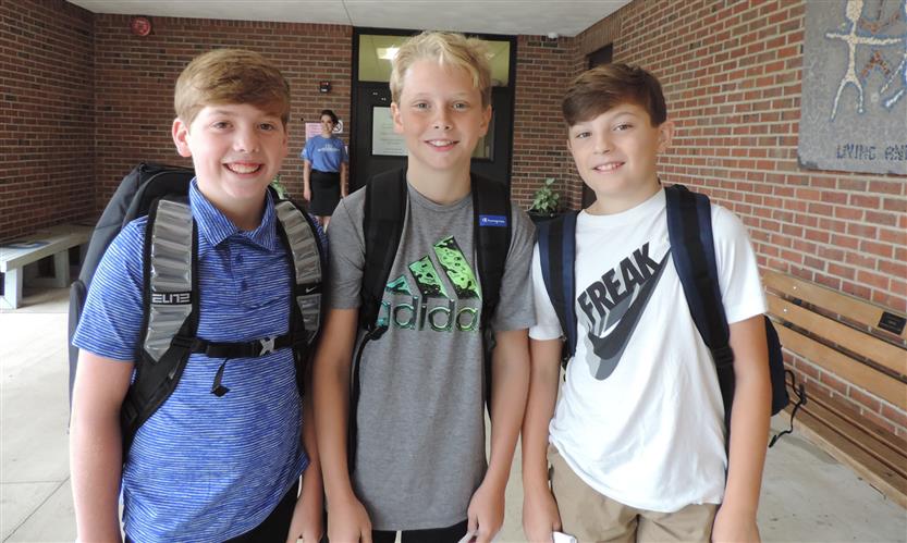 Three boys smile